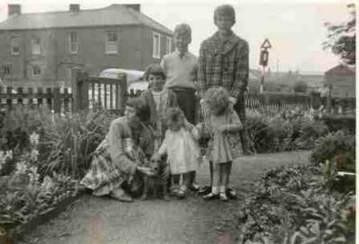 Nelson Sq
"This is another out side Grandfathers house\
Mary Willson (knelt) Elizabeth Wilson, Patricia Ward(me) Ann Wilson (Behind) Philip Ward Rosemary Ward,. and Whiskey the Dog"

